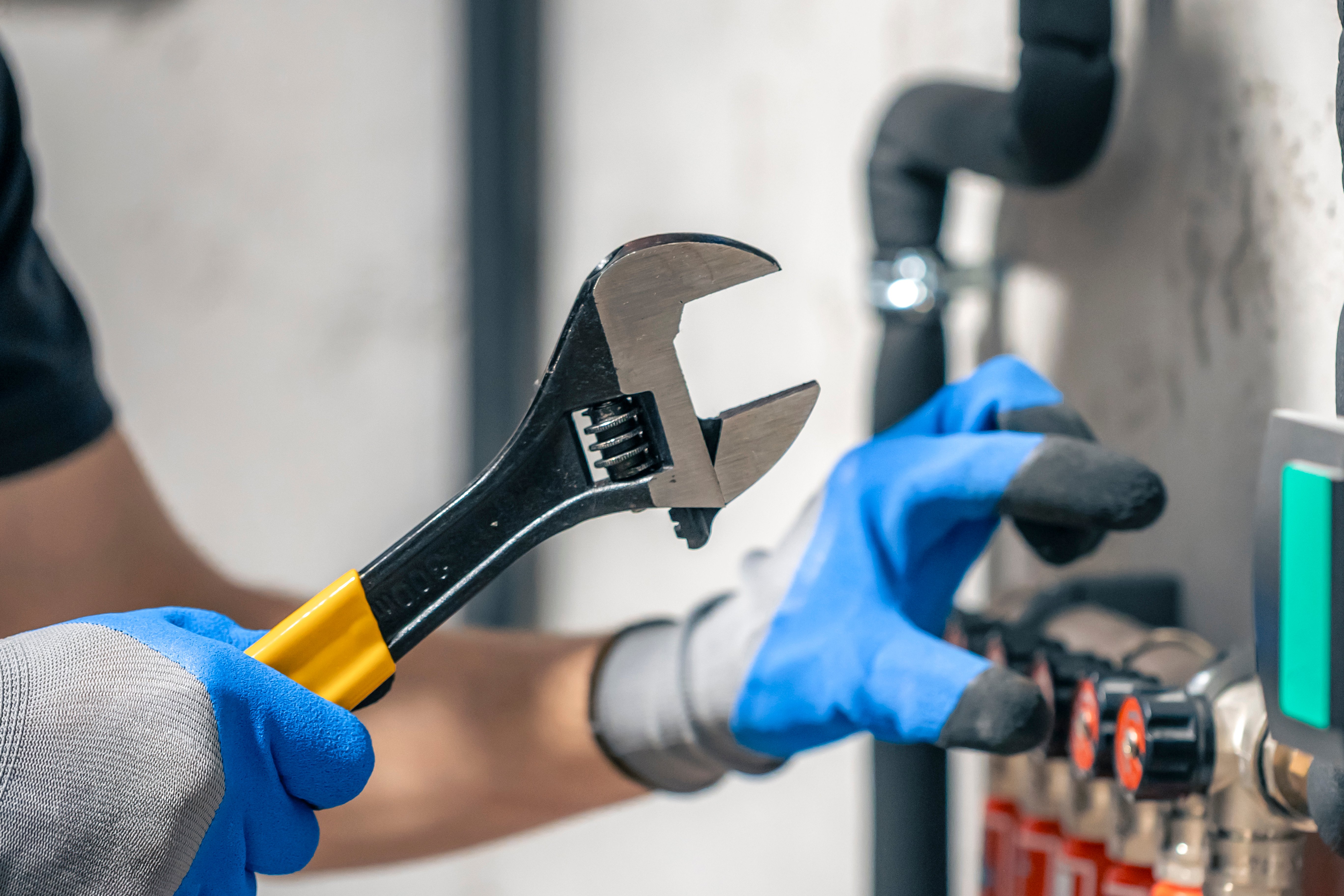 man-installs-heating-system-house-checks-pipes-with-wrench-1